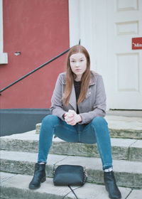 Portrait of young woman sitting outdoors