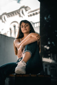 Portrait of smiling young woman sitting outdoors