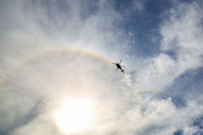 Low angle view of silhouette airplane flying against sky