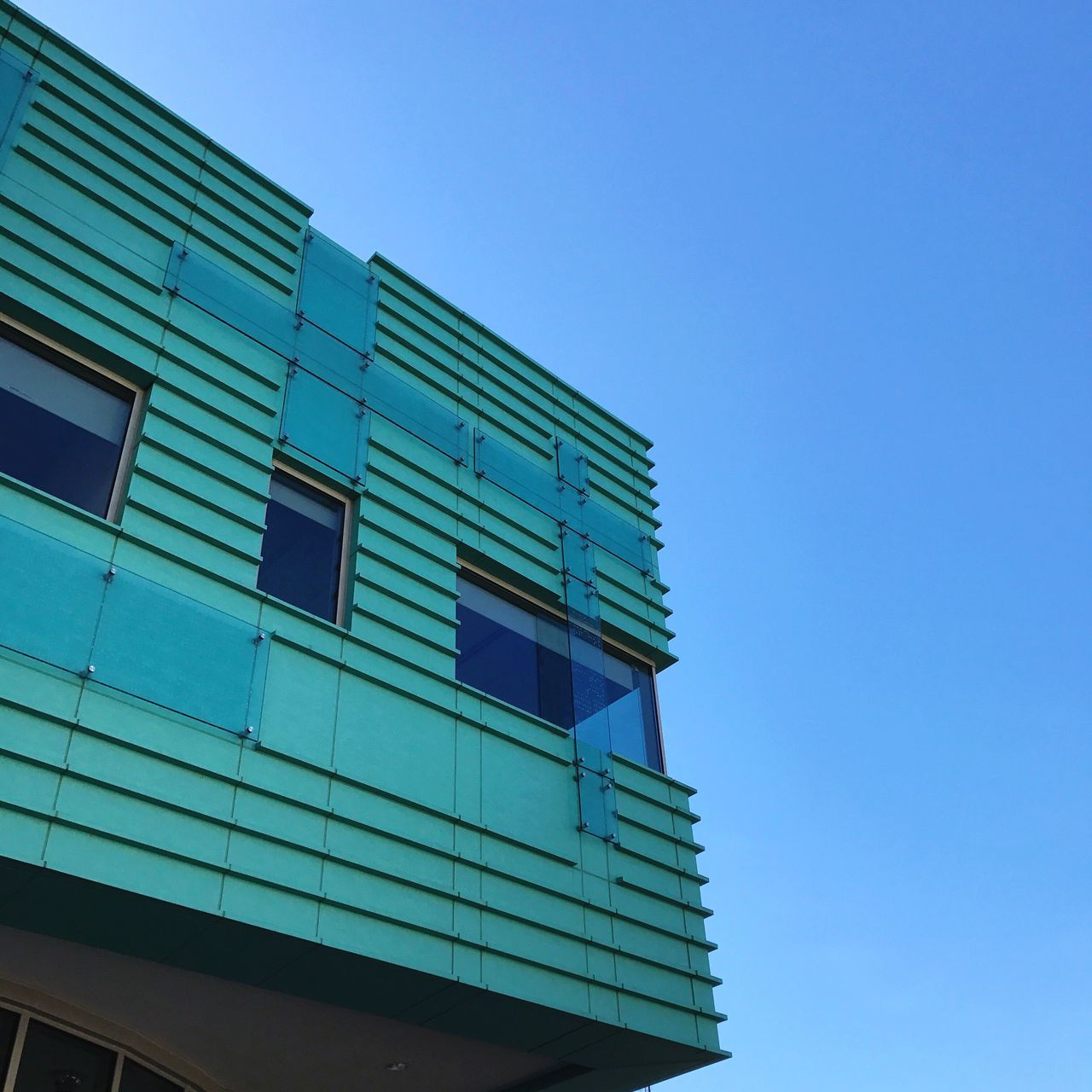 building exterior, architecture, built structure, clear sky, low angle view, blue, window, outdoors, day, no people, modern, sky, residential building, nature