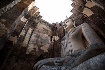 Low angle view of statues on building against sky