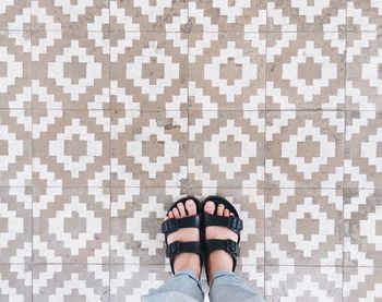 Low section of woman standing on tiled floor