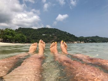 Low section of people relaxing on beach