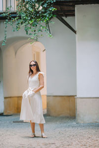 Full length of woman standing against white wall