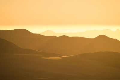 Scenic view of silhouette mountains against sky during sunset