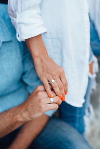 Midsection of couple holding hands