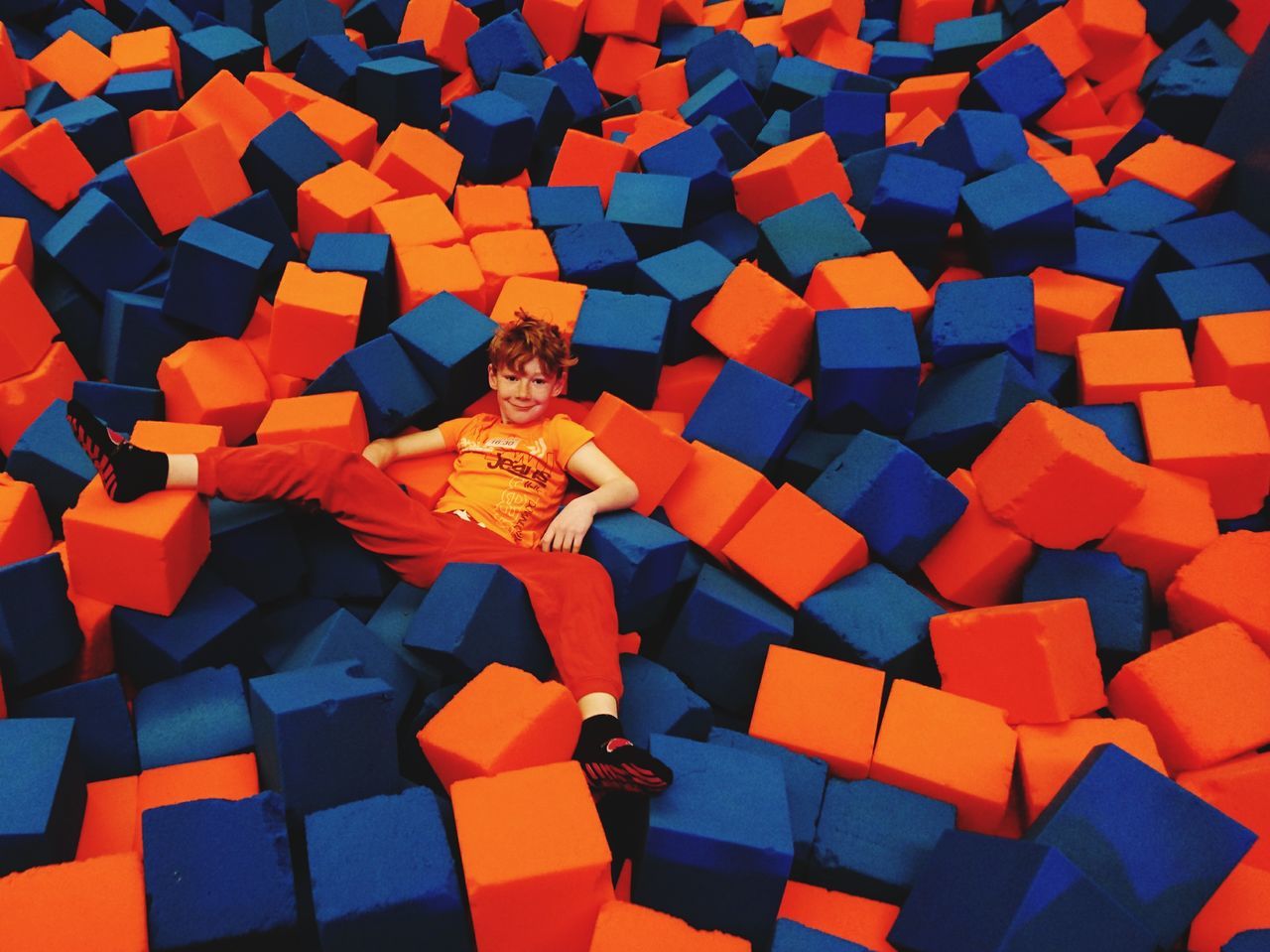 high angle view, one person, large group of objects, real people, puzzle, multi colored, seat, indoors, day, close-up, one man only, people