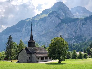 Traditional building by mountains against sky