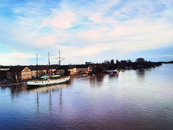 Sailboats moored in marina at sunset