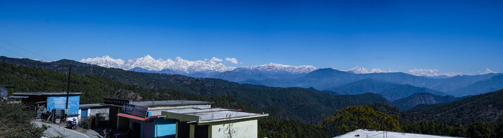 Scenic view of snowcapped mountains against clear blue sky