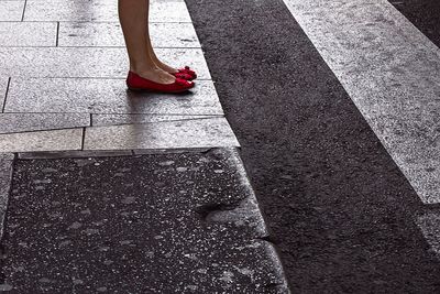 Low section of woman standing on road