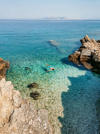 Man floating on water on beautiful beach with turquoise water on pag island in croatia.