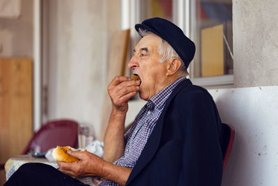 Side view of a man holding food