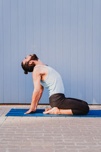 Full length of man with arms raised on floor