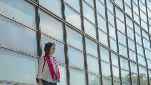 Side view of young man standing in city