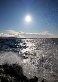 Scenic view of sea against bright sun