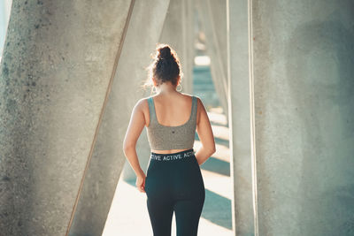 Young woman standing against wall