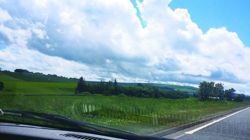 Scenic view of field against cloudy sky