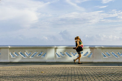 Full length of woman standing against sky