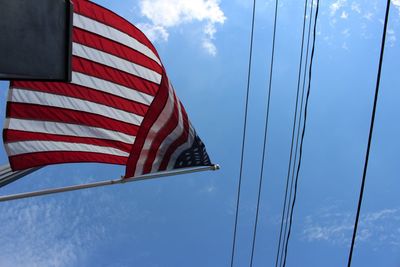Low angle view of flag against blue sky