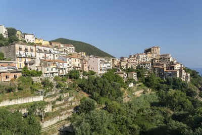 Buildings in town against clear blue sky