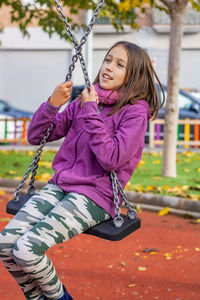 Girl sitting on swing at park