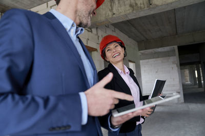 Happy female architect looking at colleague