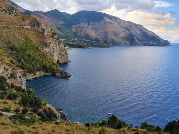 Scenic view of sea and mountains against sky