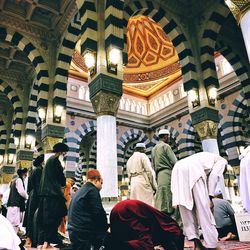 Low angle view of people at temple against building