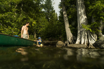 A young girl walks next to a canoe on lost lake in oregon.