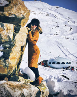 Full length of woman on rock in snow