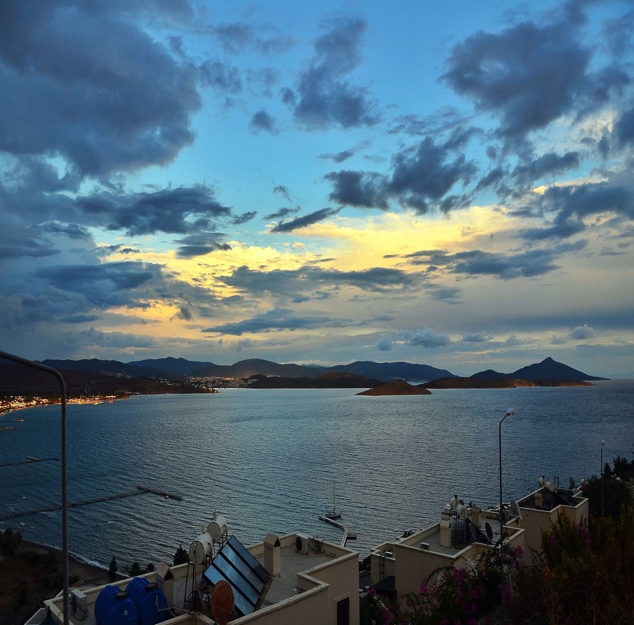 sky, water, sea, cloud - sky, scenics, beauty in nature, cloudy, cloud, mountain, tranquil scene, nature, tranquility, sunset, idyllic, building exterior, built structure, blue, outdoors, horizon over water, beach