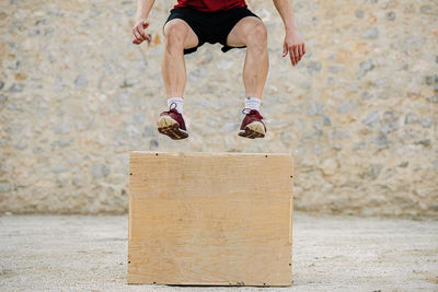 Man practicing crossfit jumping into a plyometric box.