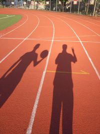 High angle view of shadow of men on sports field