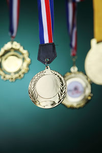 Close-up of gold medals hanging against blackboard