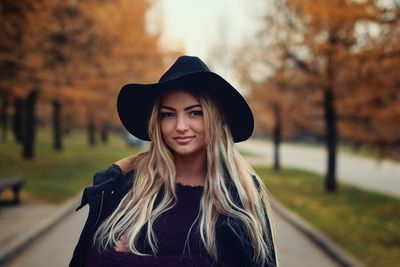 Portrait of beautiful woman standing in park during autumn