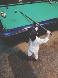 High angle view of boy playing pool