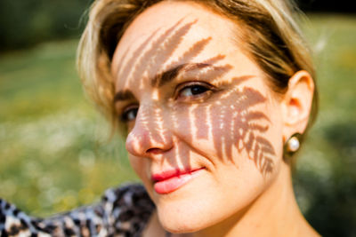 Close-up of young woman with shadows on face