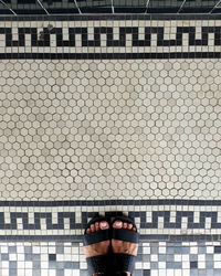 Low section of woman standing on tiled floor 