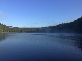 Scenic view of lake against clear blue sky