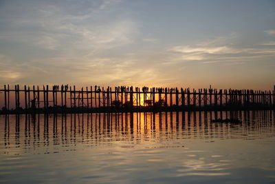 Silhouette pier on sea against sky during sunset