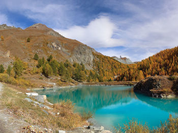 Scenic view of lake by mountain against sky