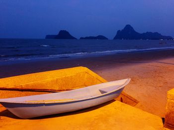 Boat moored on beach against clear sky