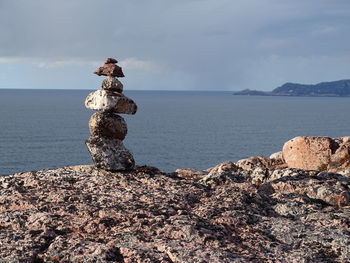 Stack of rocks on shore against sky