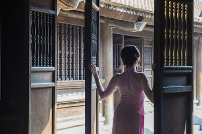 Rear view of woman standing at temple