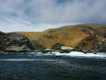 Scenic view of sea and mountains against sky