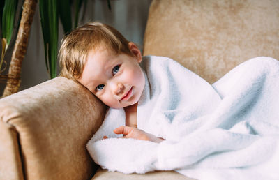 Portrait of cute baby girl lying at home