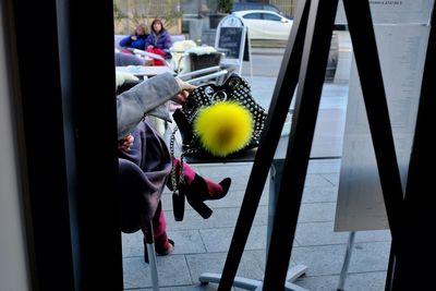 Midsection of woman with umbrella on glass window