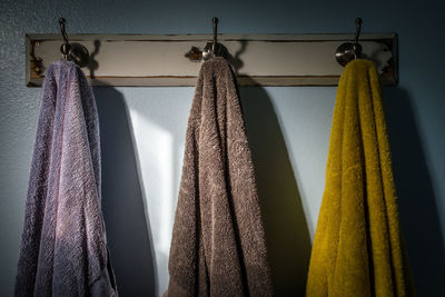 Towels hanging on hook against wall in bathroom