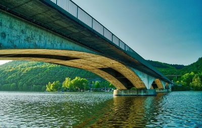 Arch bridge over river against sky